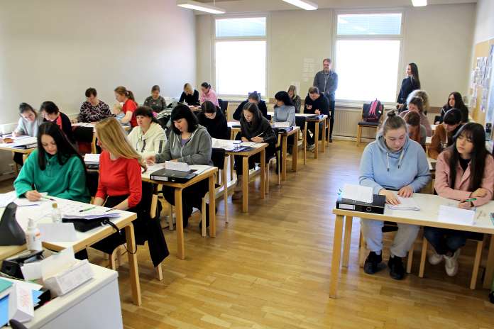 Hirvikoskelle saapuneet ukrainalaiset aikuiset opiskelevat suomen kieltä Loimaan Evankelisessa Kansanopistossa. Taustalla ikkunoiden luona ovat opiston koulutuspäällikkö Kimmo Vanha-Juhe ja tulkkina toimiva opiskelija Liuba Koshara.