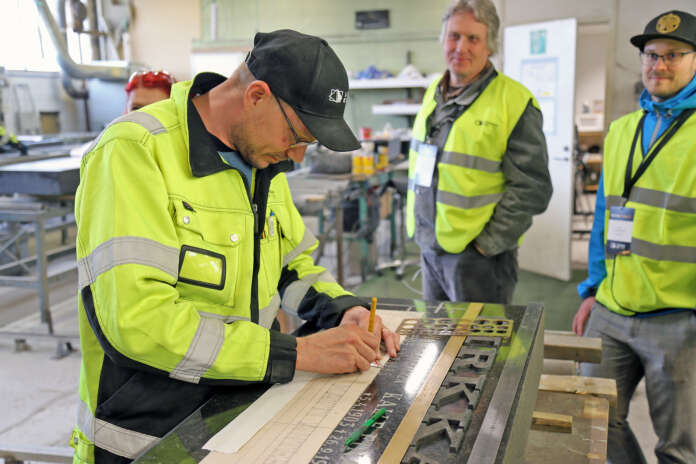 Ben Pennanen ja Elias Naukkarinen seurasivat tarkasti miten Mikko Rautio asetteli hautakiveä millintarkasti kaiverruskuntoon.