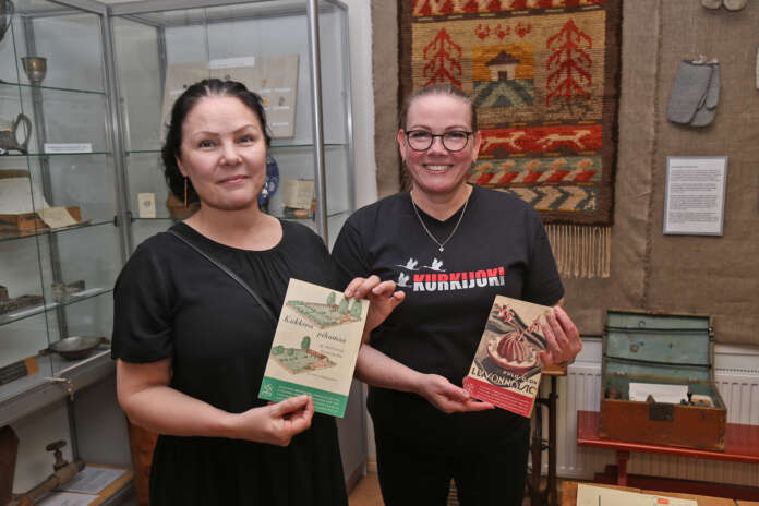 Kurkijoki-museon museotoimikunann jäsenet Outi Terentjeff ja Taina Suvila kertovat esille valikoituneen vanhimpia Martta-aiheisia julkaisuja, kuten kuvassa näkyvät puutarha- ja pula-ajan leivontaoppaat.
